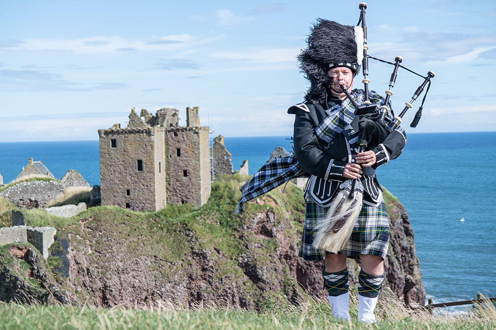 Traditional-scottish-bagpiper-at-Dunnottar-Castle